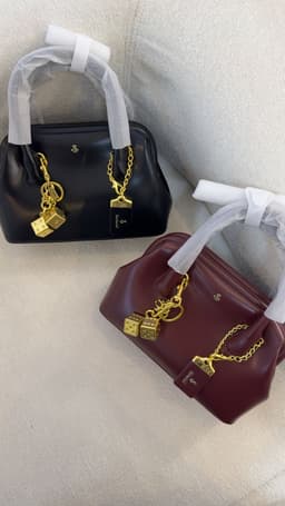 Charm on black and burgundy bag