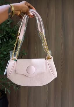 Hand holding a pink bag